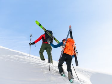 in use image Couloir dark lava and black backview with skis tied on the side