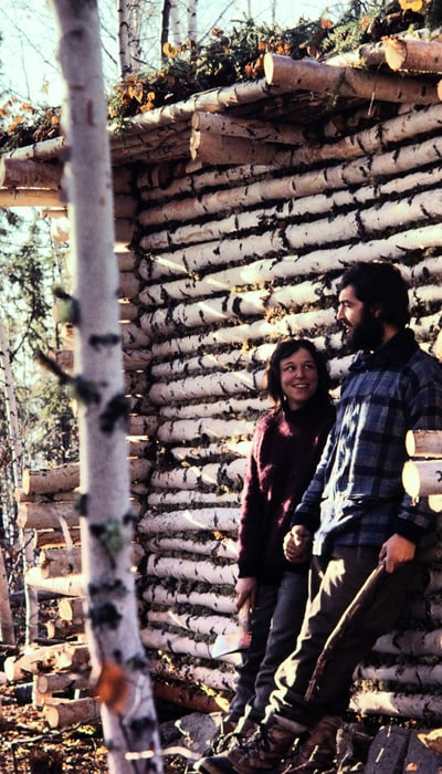 Andi and Heidi in front of their log cabin