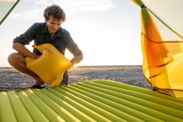 Sleeping mat in a Tent - man with a Schnozzel Pumpbag on the beach